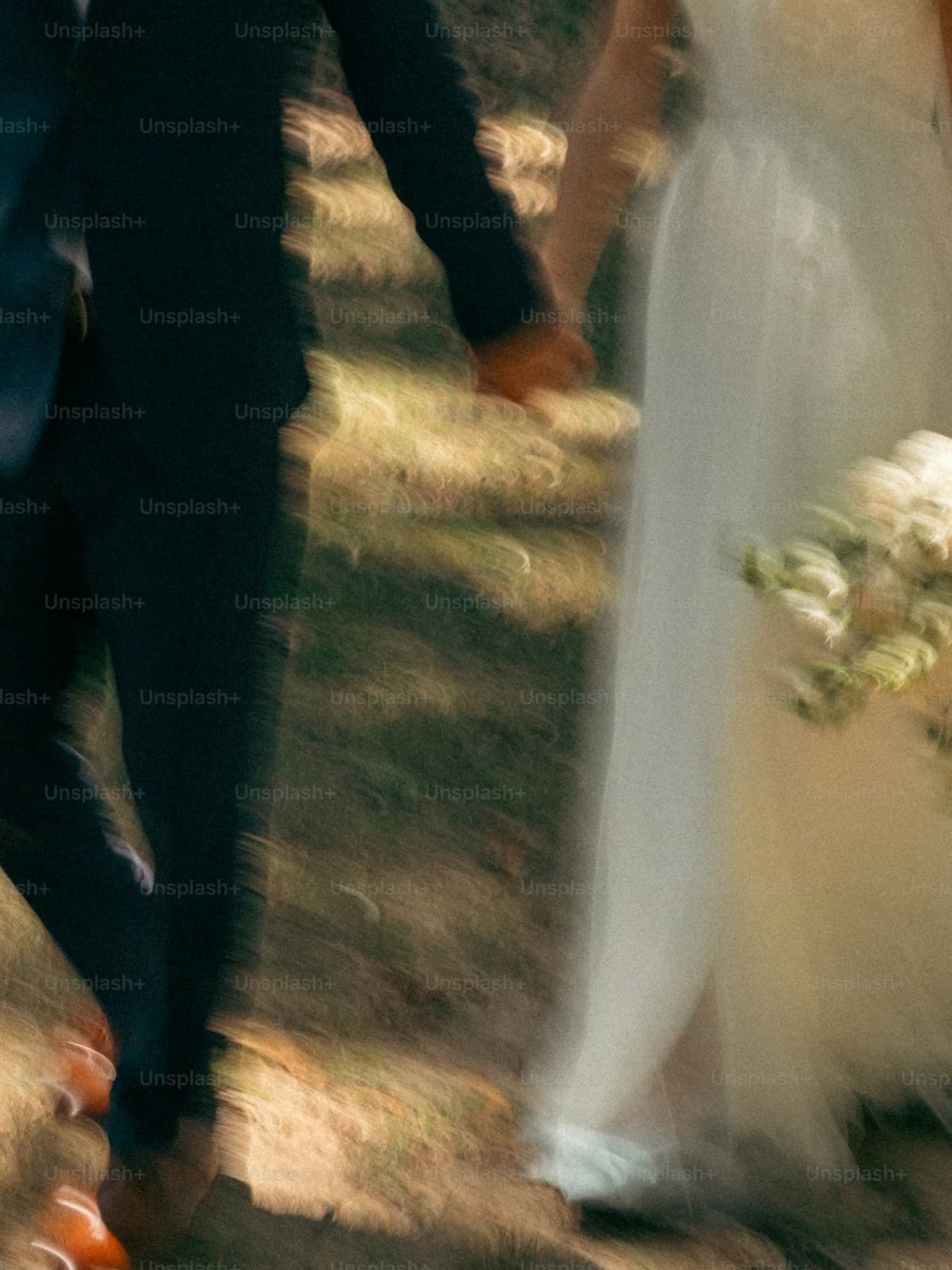A bride and groom walking hand in hand through the woods