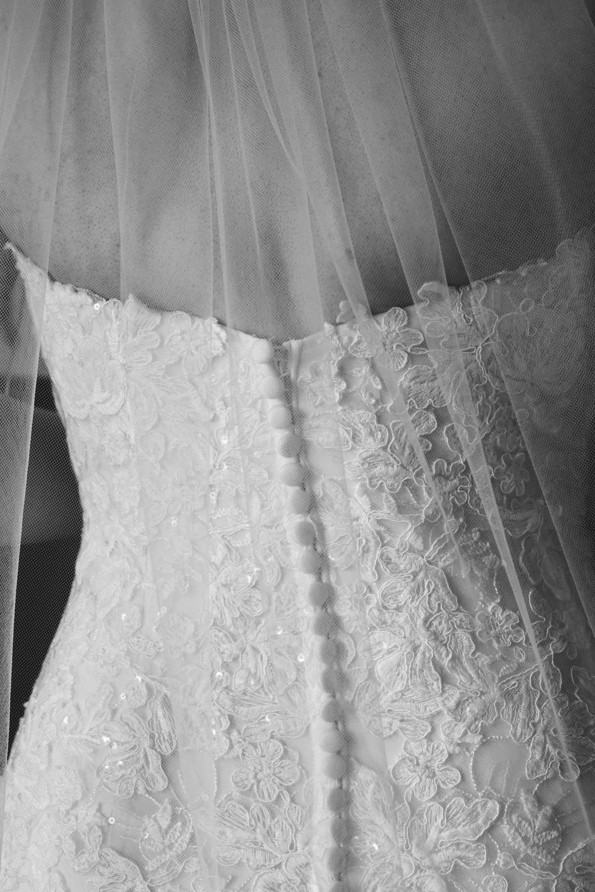 A white lace wedding dress on a hanger