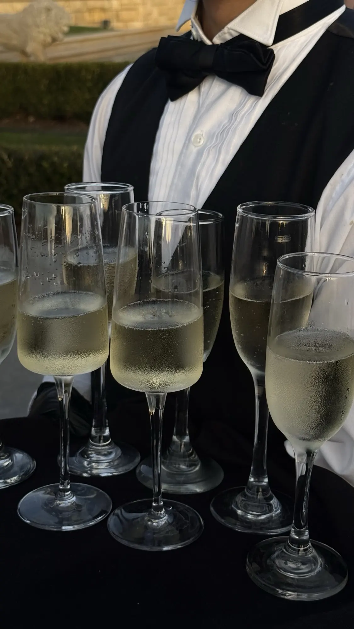 A waiter carrying a tray of champagne flutes at a wedding