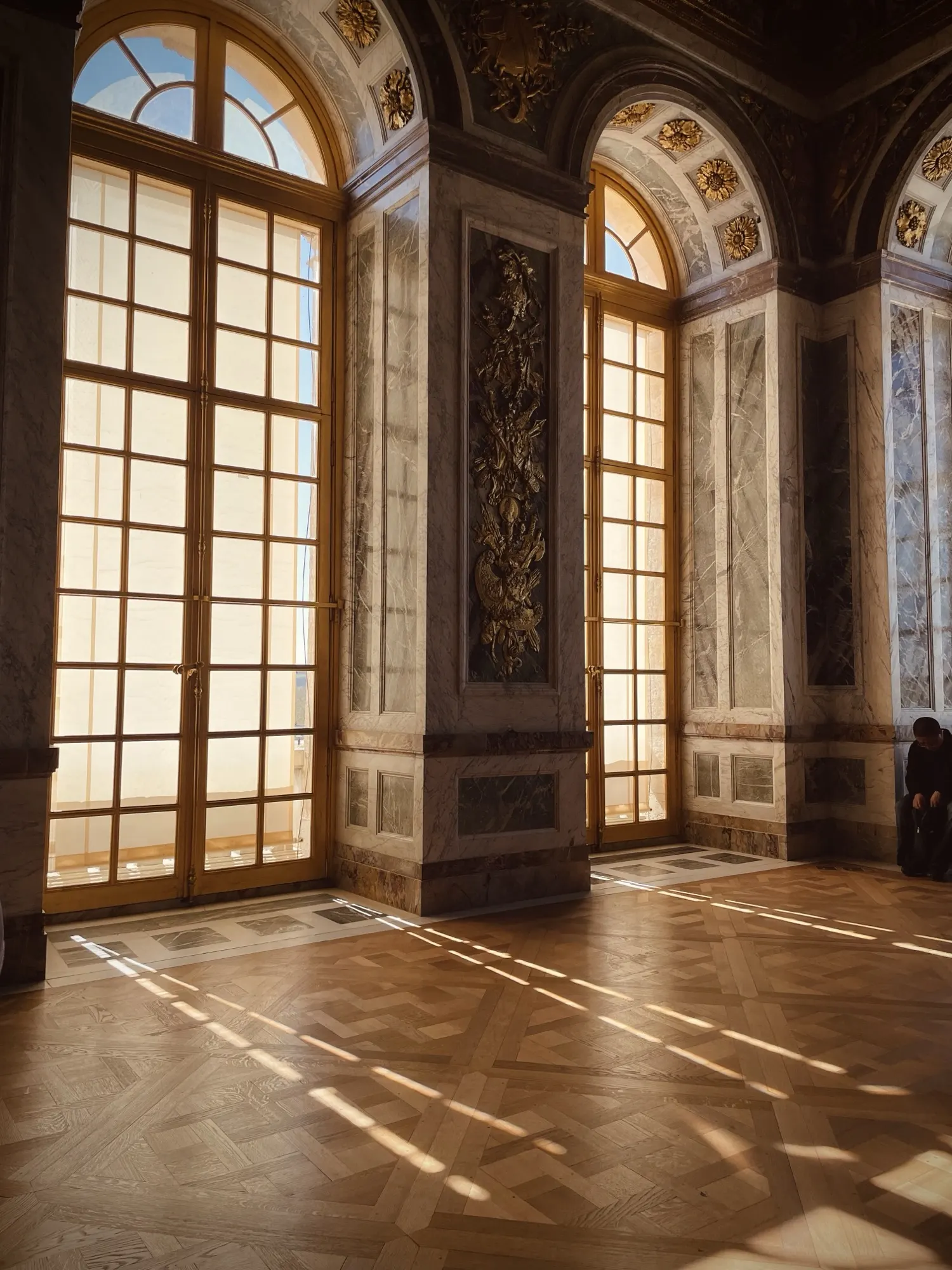 A palace hall with tall arched windows set for a wedding